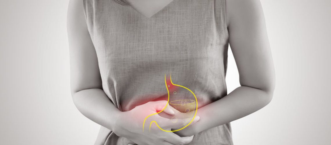 Woman suffering from gastroesophageal reflux disease or Acid reflux standing against gray background, Female Anatomy Concept